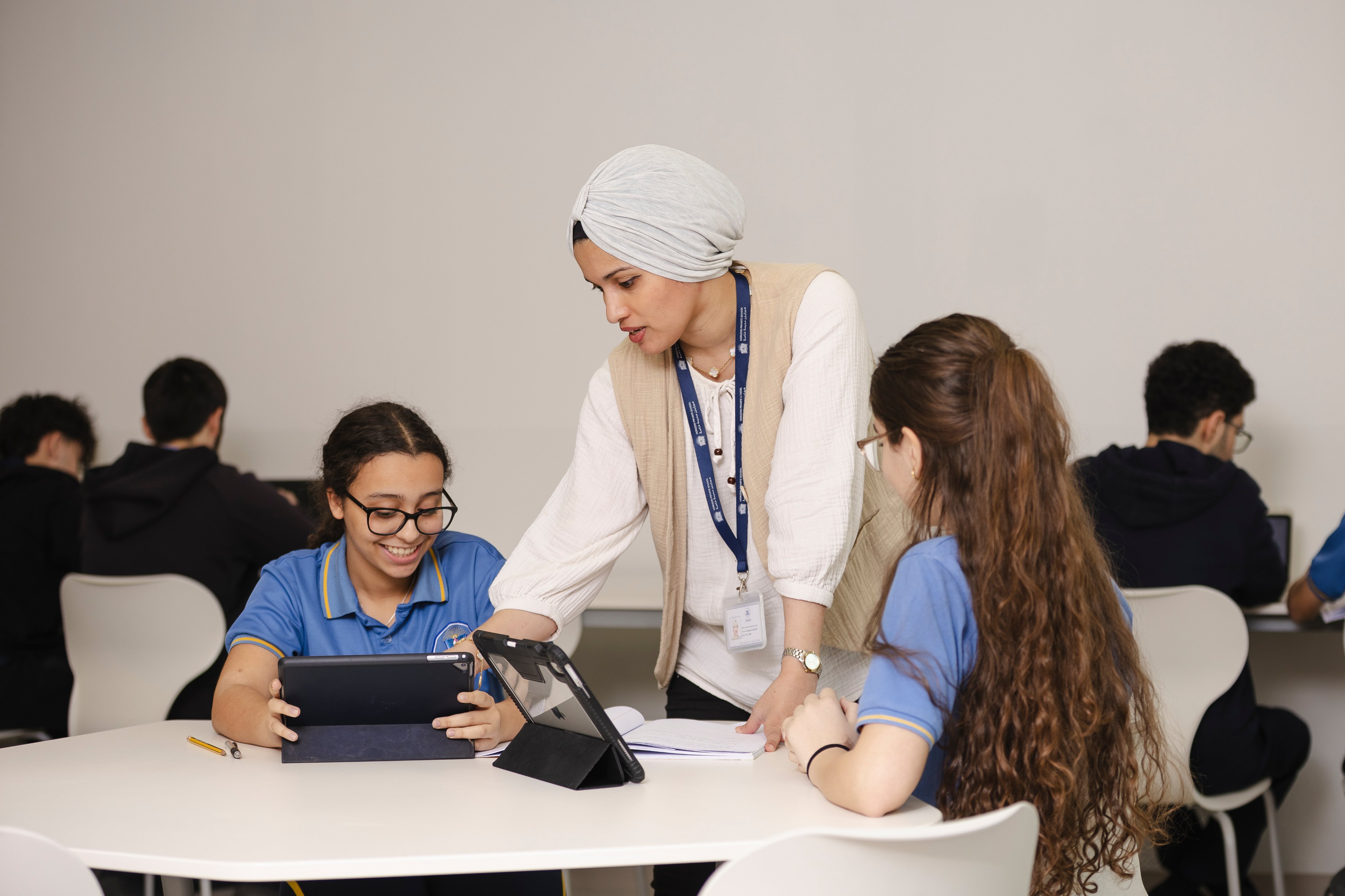 Teacher assisting a student with a tablet in a science lab